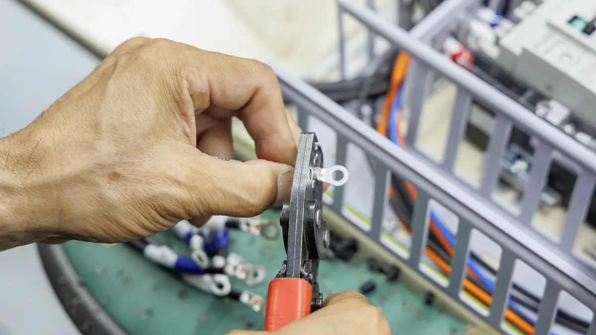 圧着工具でリング端子を圧着する手元